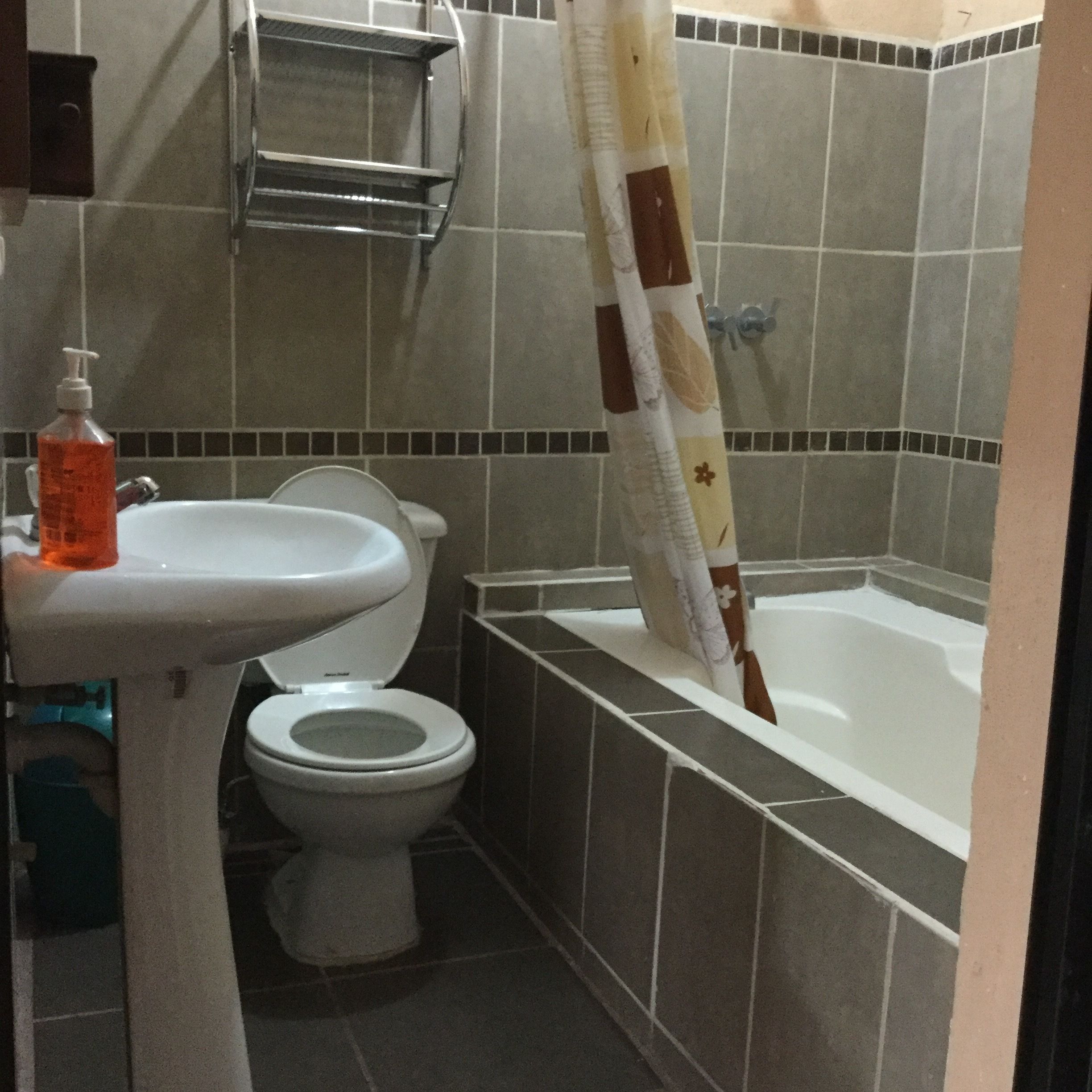 A bathroom with a toilet, sink, and bathtub.