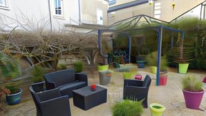 An outdoor patio area with seating, potted plants, and a covered structure. - Logis Hôtel Le Pélican & son restaurant (Vernantes)