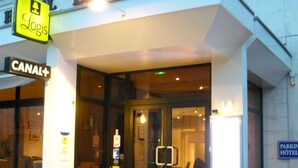The exterior of the Pelican hotel with a visible entrance, steps leading up to the door, and a sign for Canal+ on the left. - Logis Hôtel Le Pélican & son restaurant (Vernantes)