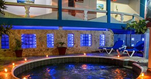 A spa area with a hot tub, blue chairs, and potted plants. - Hotel Tronco Inc (Boca Chica)