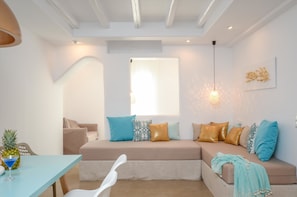 Deluxe Suite | Living area | 43-inch flat-screen TV with satellite channels, TV, books - Ktima Lino (Naxos)