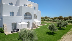 A modern white building with multiple balconies and outdoor seating areas. - Ktima Lino (Naxos)