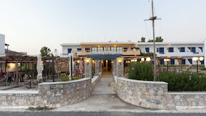 A restaurant with a stone facade and outdoor seating. - Olympia Hotel (Syros)