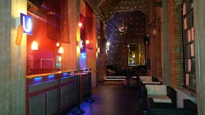 Una zona de bar con mostrador, taburetes y una pared con diseño.
