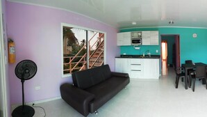 A compact living space with a kitchenette, a dining area, and a sofa.