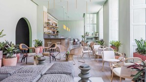 A spacious lounge area with multiple seating options, including sofas and chairs, and a bar area with shelves stocked with various items. - Eden Locke (Edinburgh)