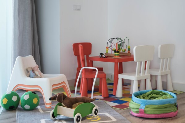 A child's play area with a small table, chairs, a toy car, and a ball pit. - Upon Lisbon Prime Residences (Lisbon)