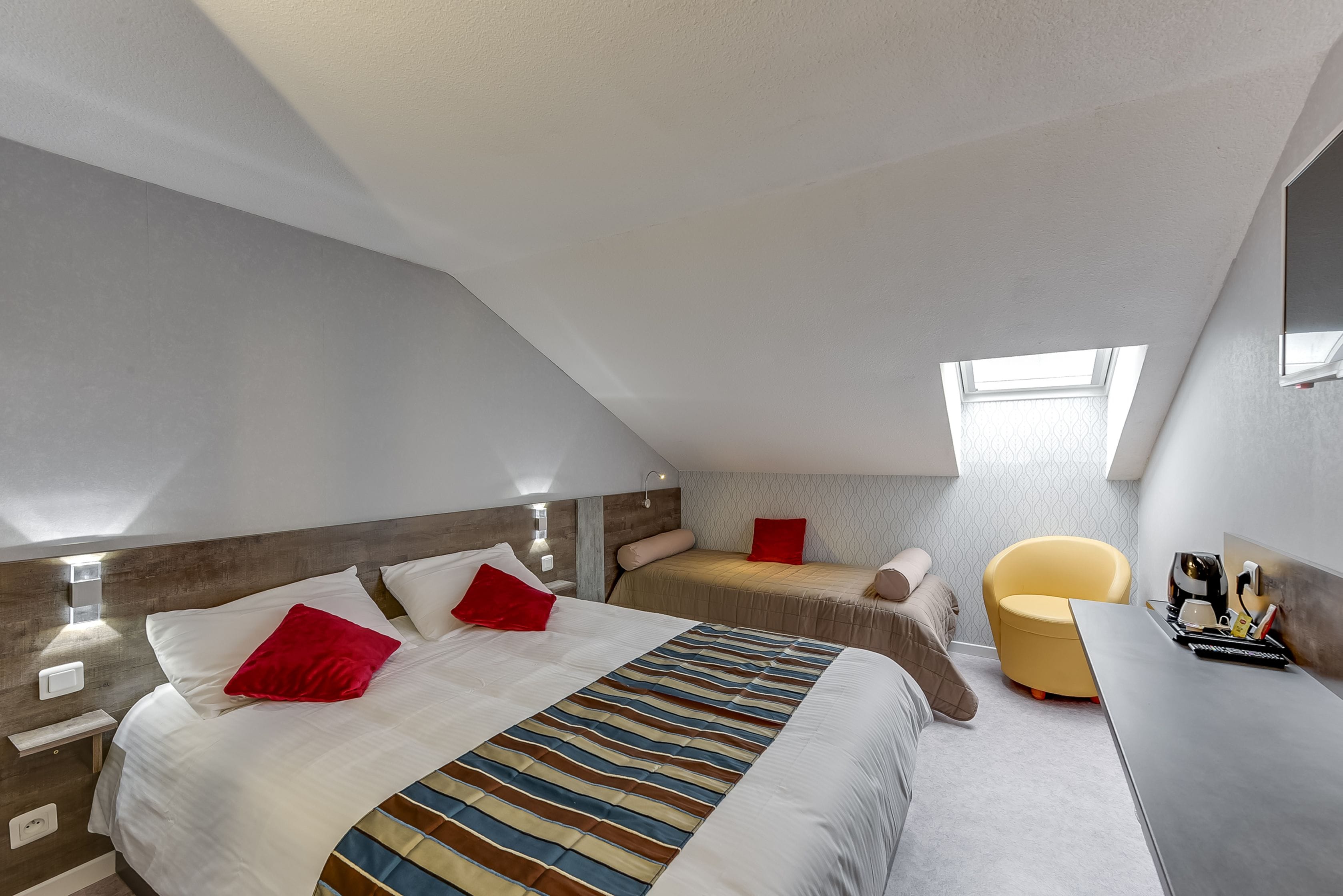 Una habitación de hotel moderna con dos camas, un escritorio y una silla.