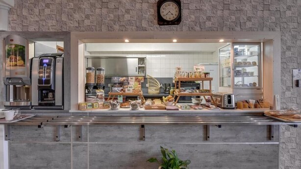 A bakery counter with various baked goods and a coffee machine. - ConfortT Hotel Thouars (Thouars)
