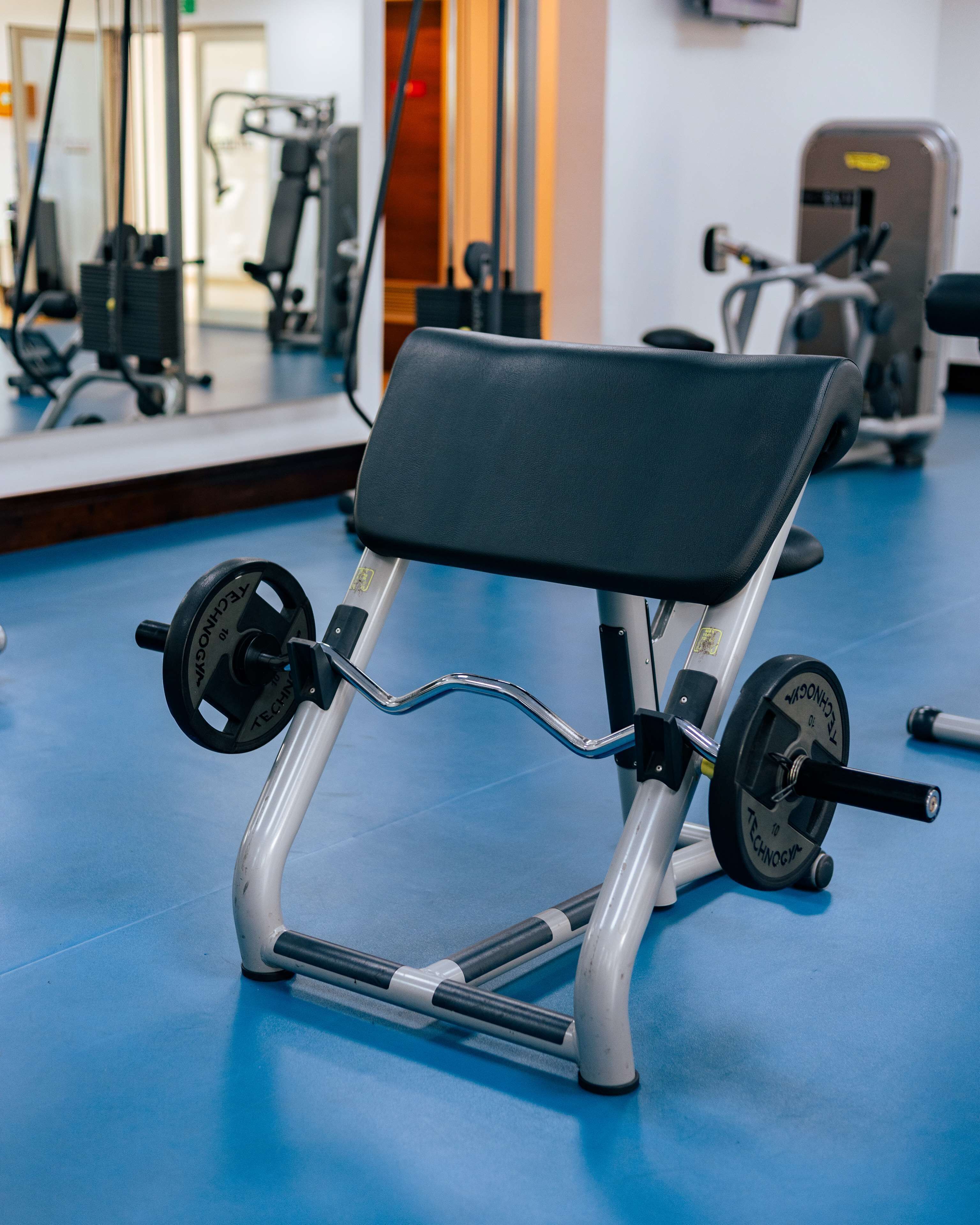 Une salle de sport équipée d’un banc de développé couché et de poids.