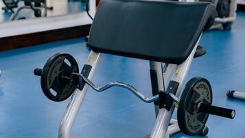 Une salle de sport équipée d’un banc de développé couché et de poids.