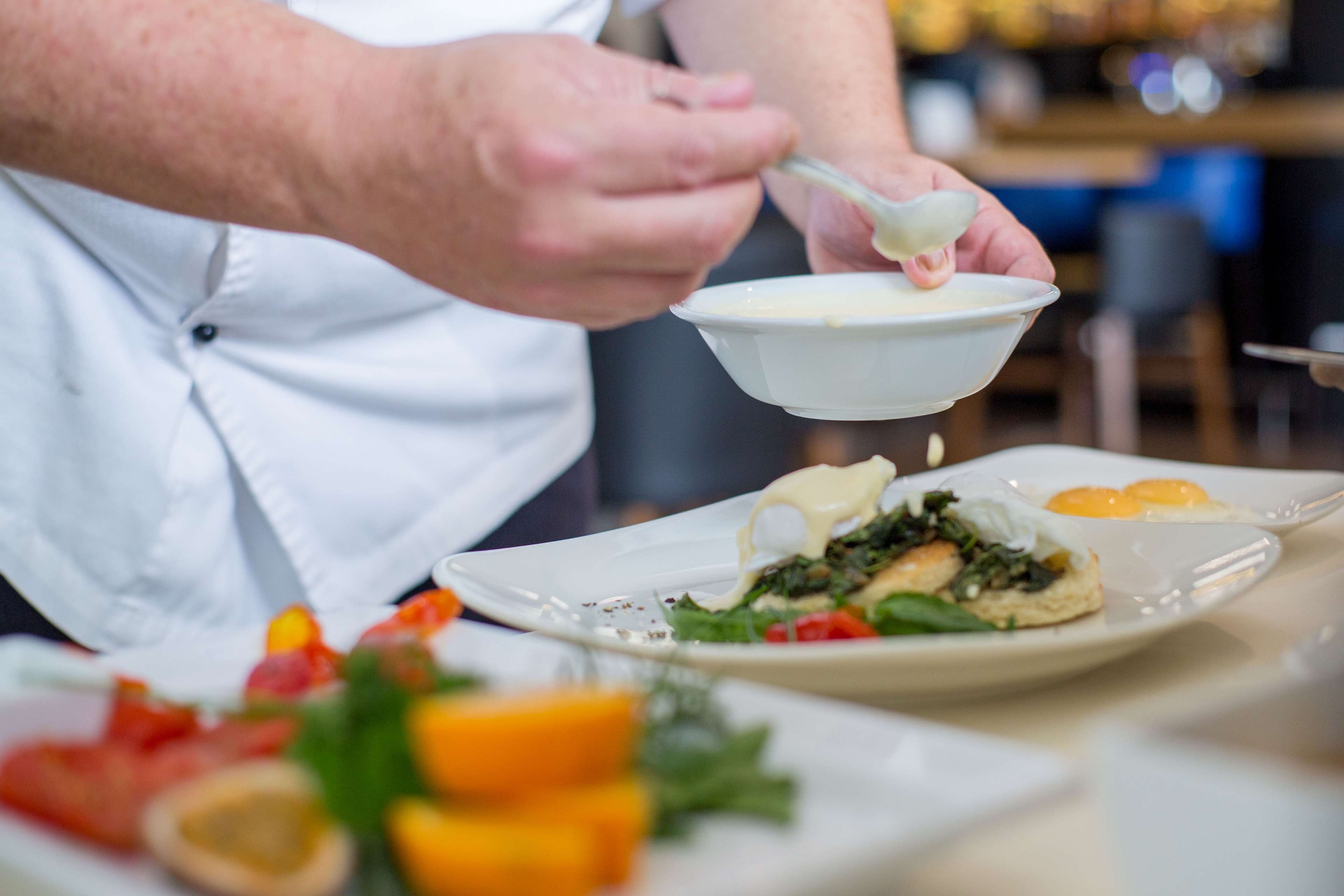 A person serving food from a bowl onto a plate.