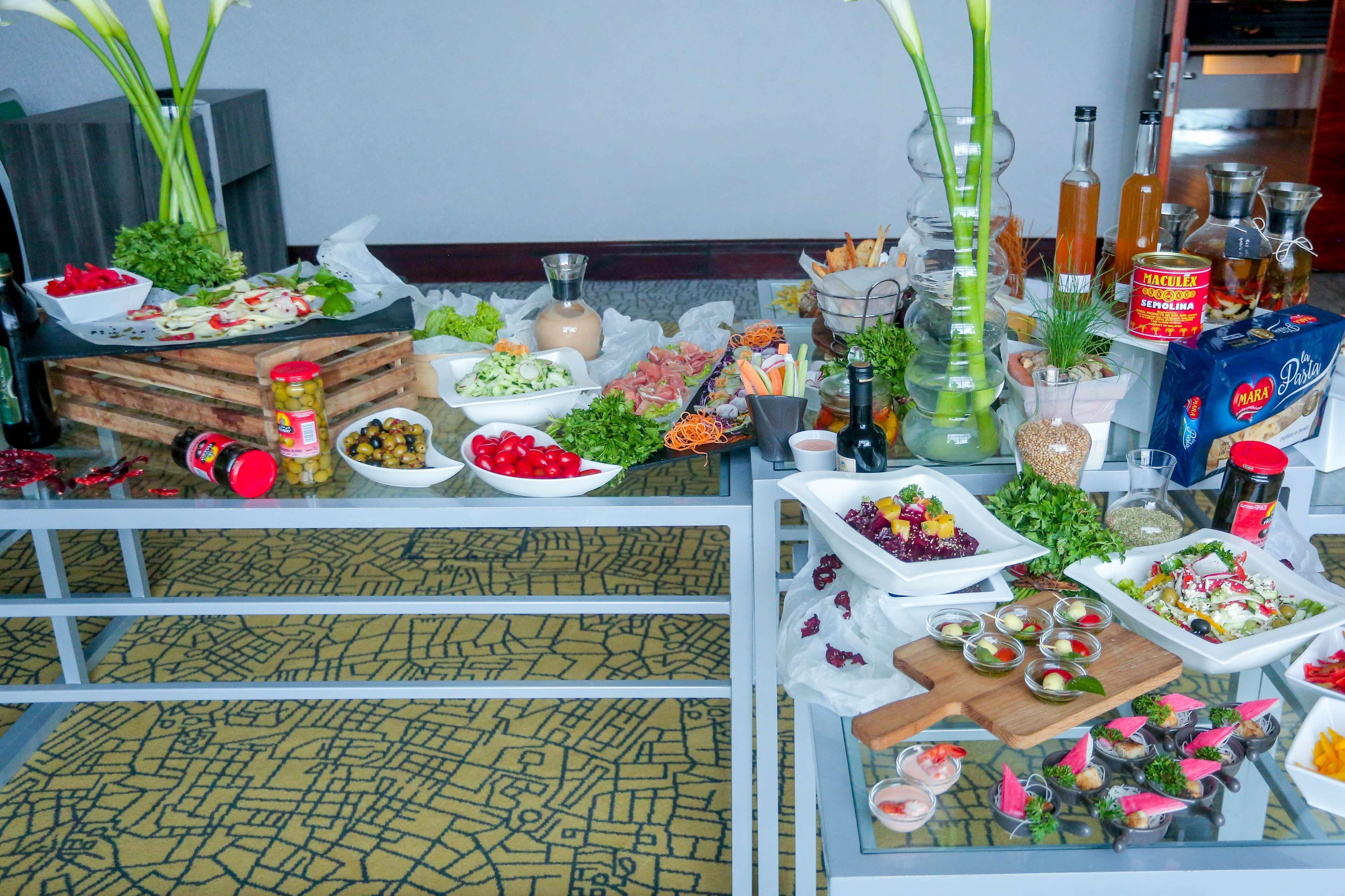 A buffet table with various food items and condiments.