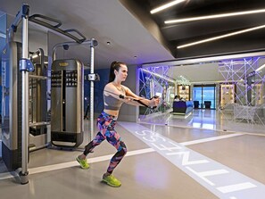 Een moderne sportschool met fitnessapparatuur, een receptie en een glazen wand.