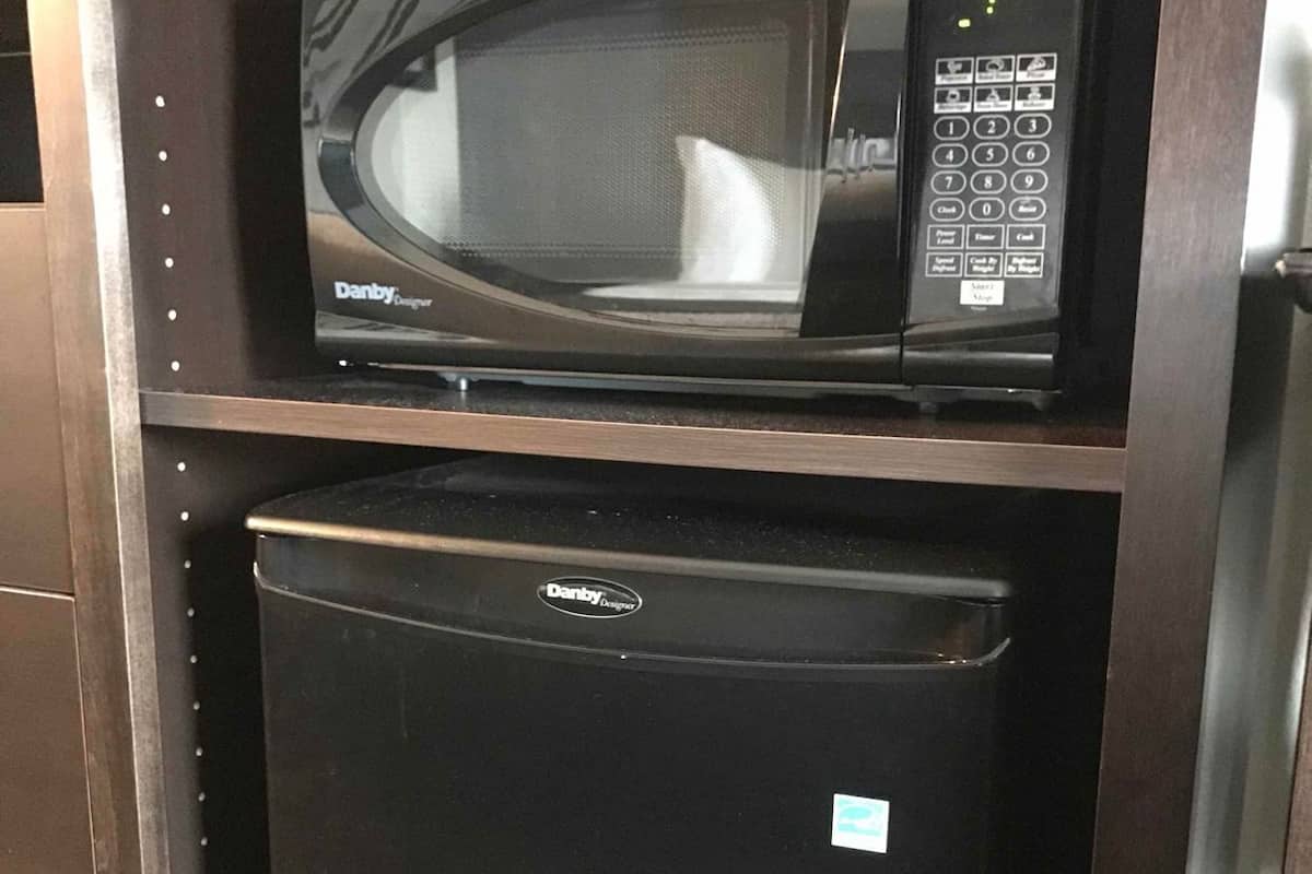 A compact kitchen with a microwave and a refrigerator.