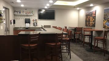 A modern dining area with a central island, bar stools, and a flat-screen TV mounted on the wall.