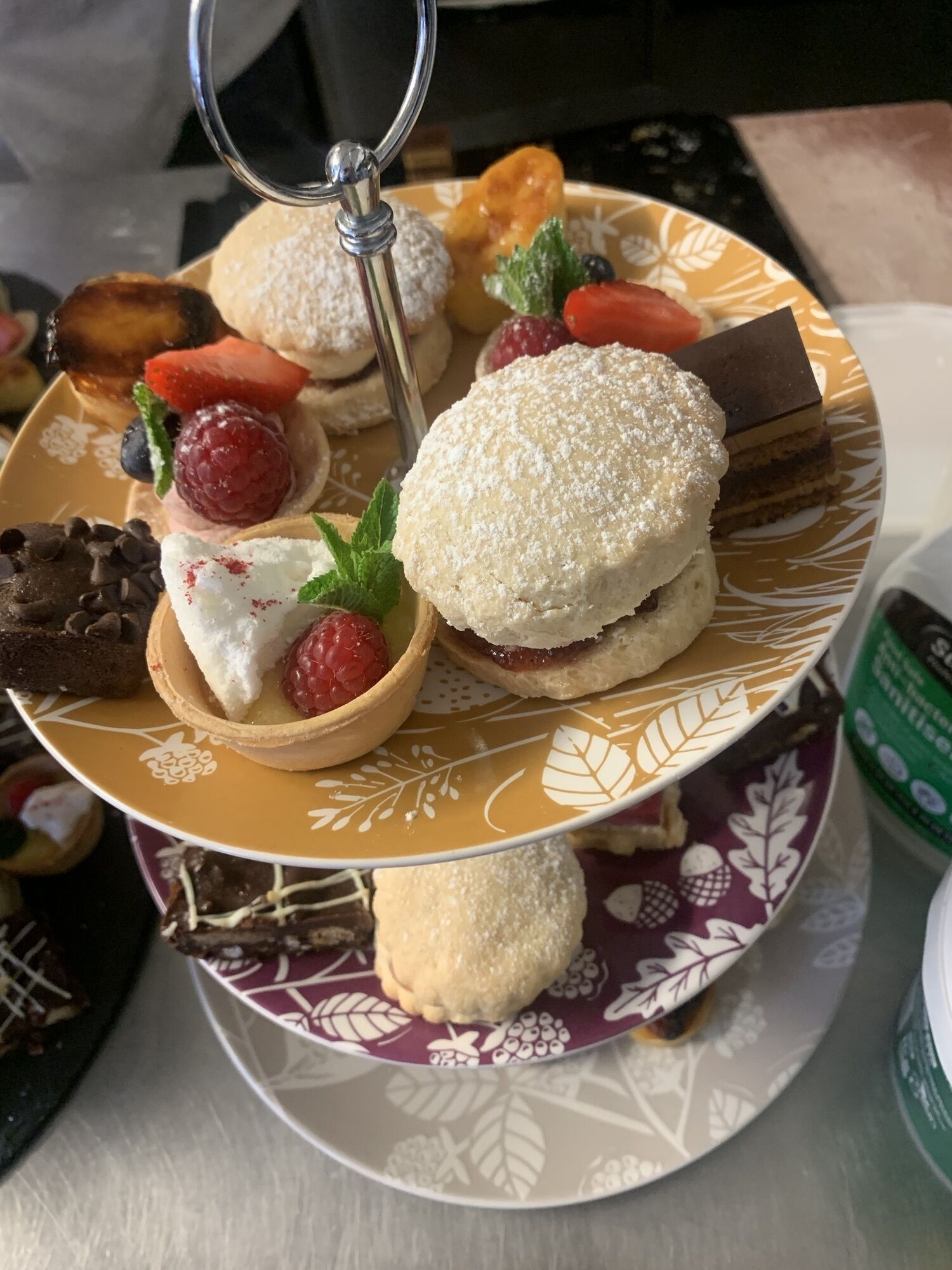 Un expositor escalonado para postres con diversos pasteles y dulces.