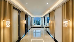Un corredor de hotel moderno con vistas a la ciudad, suelos pulidos e iluminación ambiental.