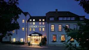 A hotel building with illuminated signage, a welcoming entrance, and a well-lit facade.