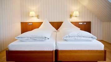 Un letto matrimoniale con una testiera in legno, due abat-jour e un pavimento in legno.