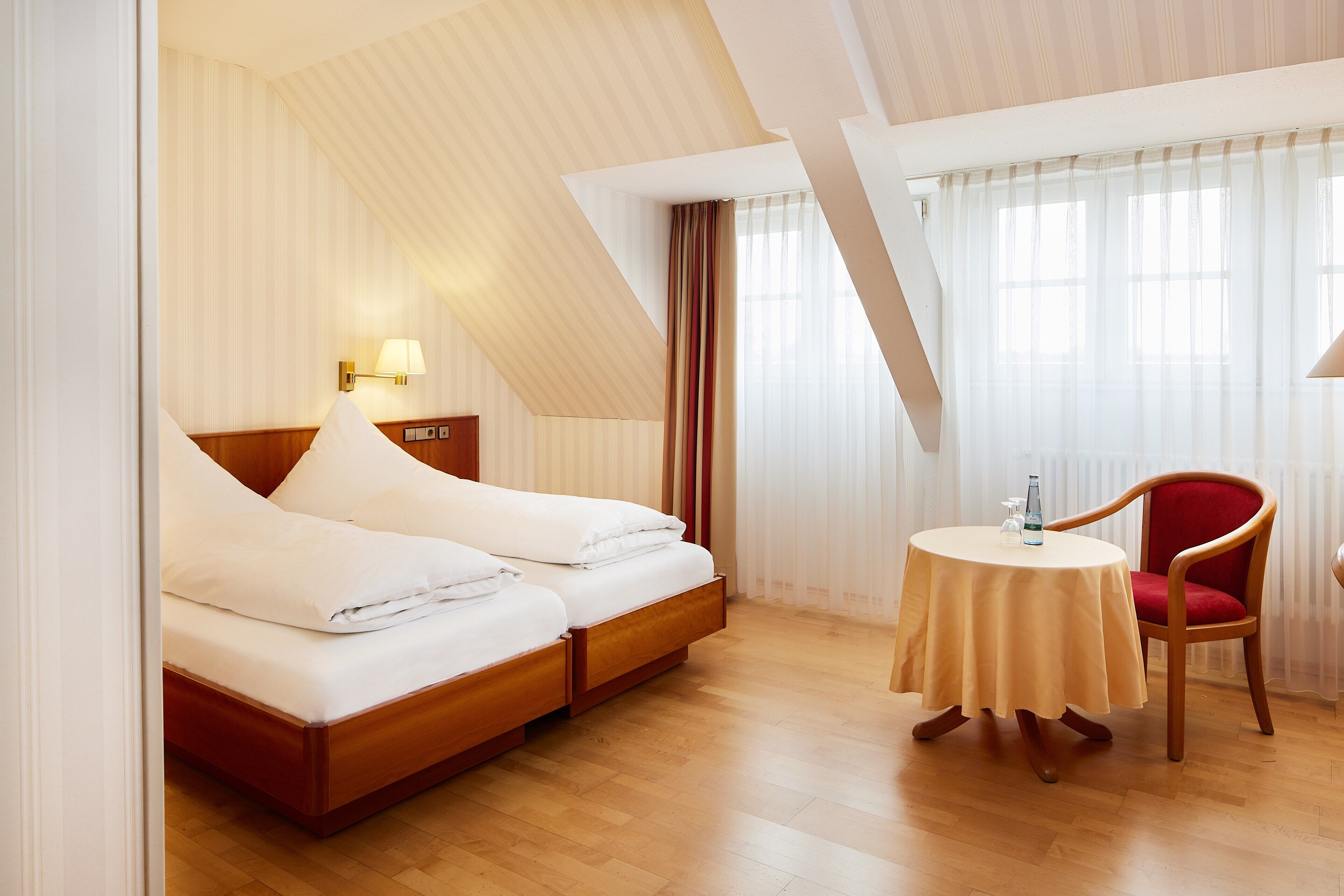 Una habitación de hotel con una cama, una mesa y una silla.