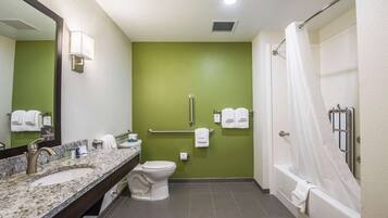 Un baño con pared verde, un lavabo, un inodoro, una bañera y una cortina de ducha.