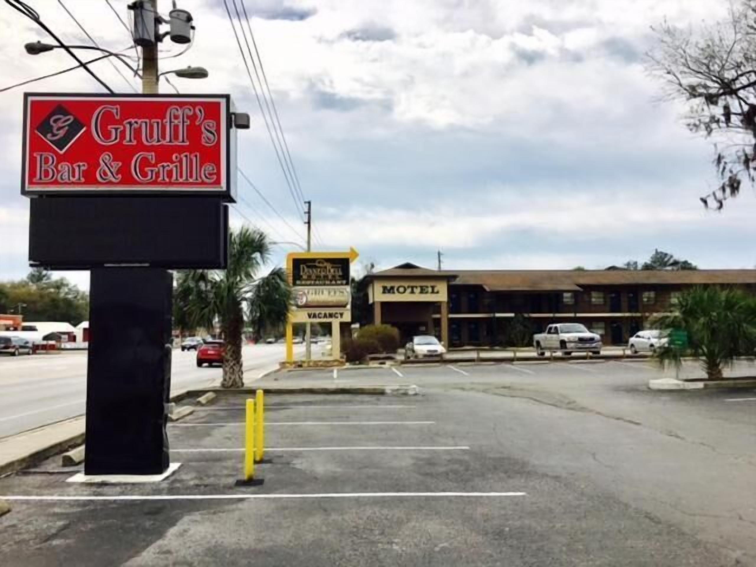 Schild von Gruff's Bar & Grill, ein Motel und eine leere Werbetafel.