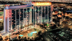 Un hotel grattacielo con un grande cartello con la scritta "SILVERTON", numerosi piani e un'area piscina.