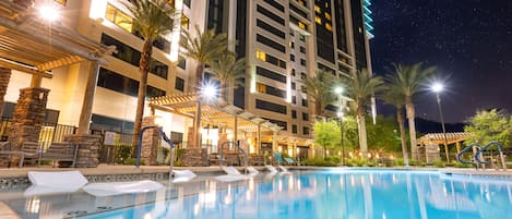 Una piscina al aire libre, sillones reclinables de piscina