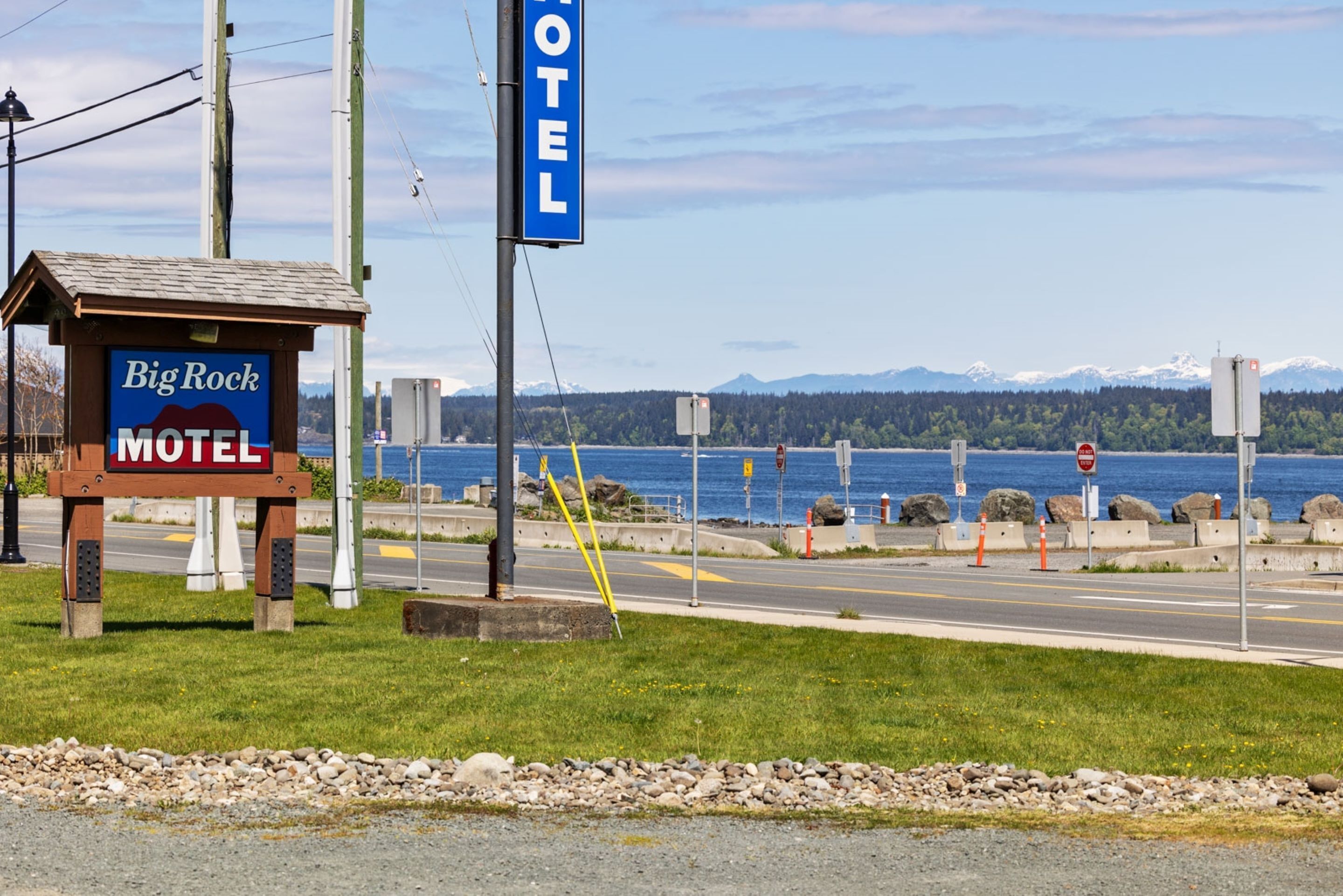 En skylt för ett motell med texten ”Big Rock Motel” och en blå skylt med texten ”HOTEL” i bakgrunden.