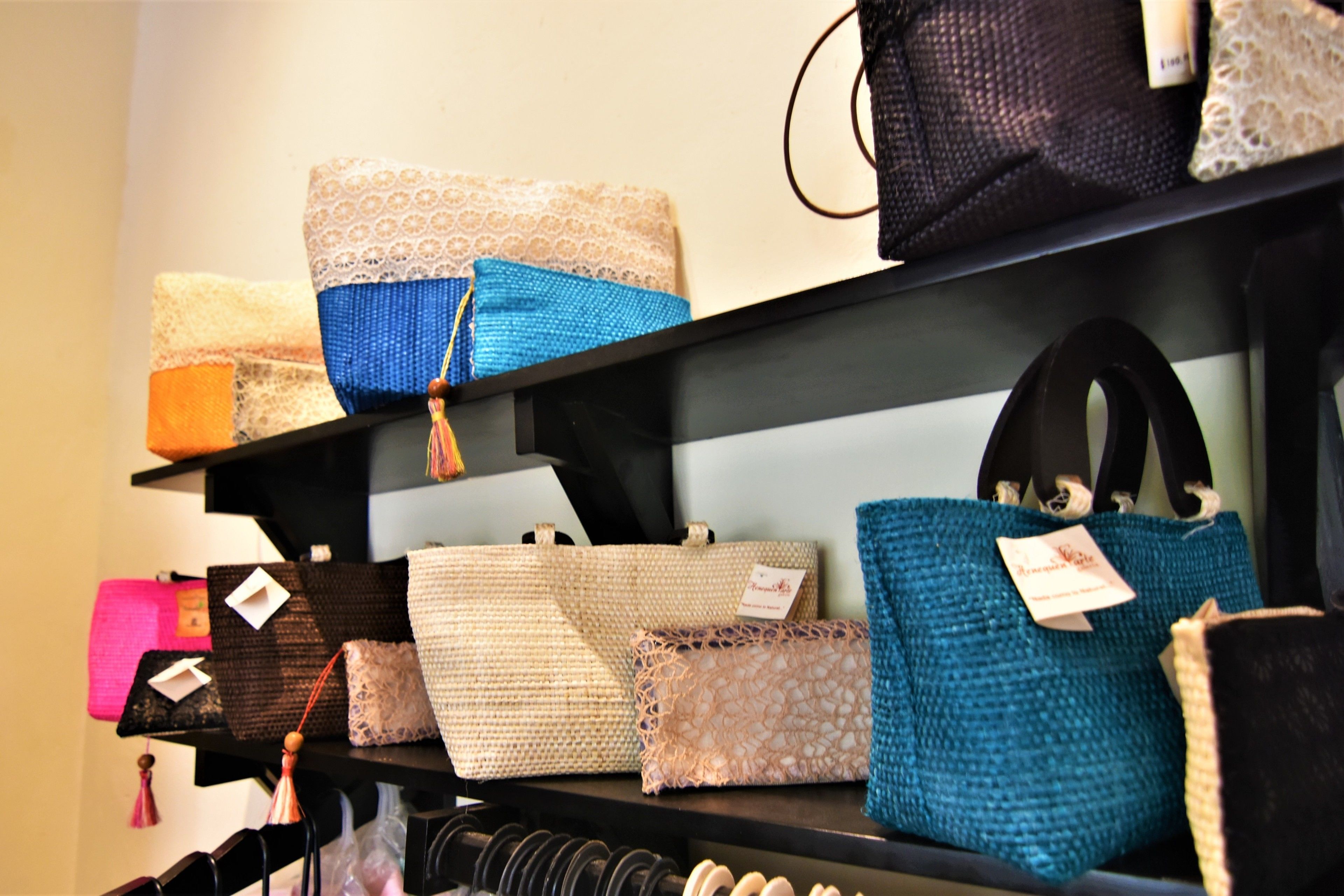Une exposition de sacs à main présentés sur des étagères.