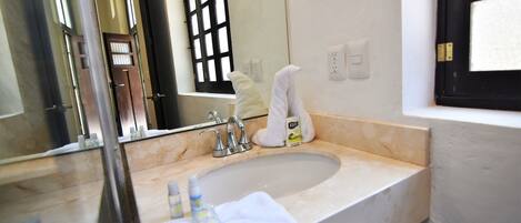 A bathroom with a sink, mirror, and towel rack.