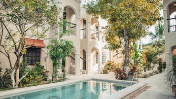 Una piscina al aire libre, sillones reclinables de piscina