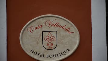 A circular plaque with the text "Casa Valladolit Hotel Boutique" and a crest.