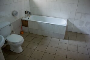 A bathroom with a toilet, a bathtub, and a sink. - Oak Hotels (Lagos)