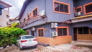A multi-story building with a car parked in front. - Peerage Retreat and Resort (Lagos)