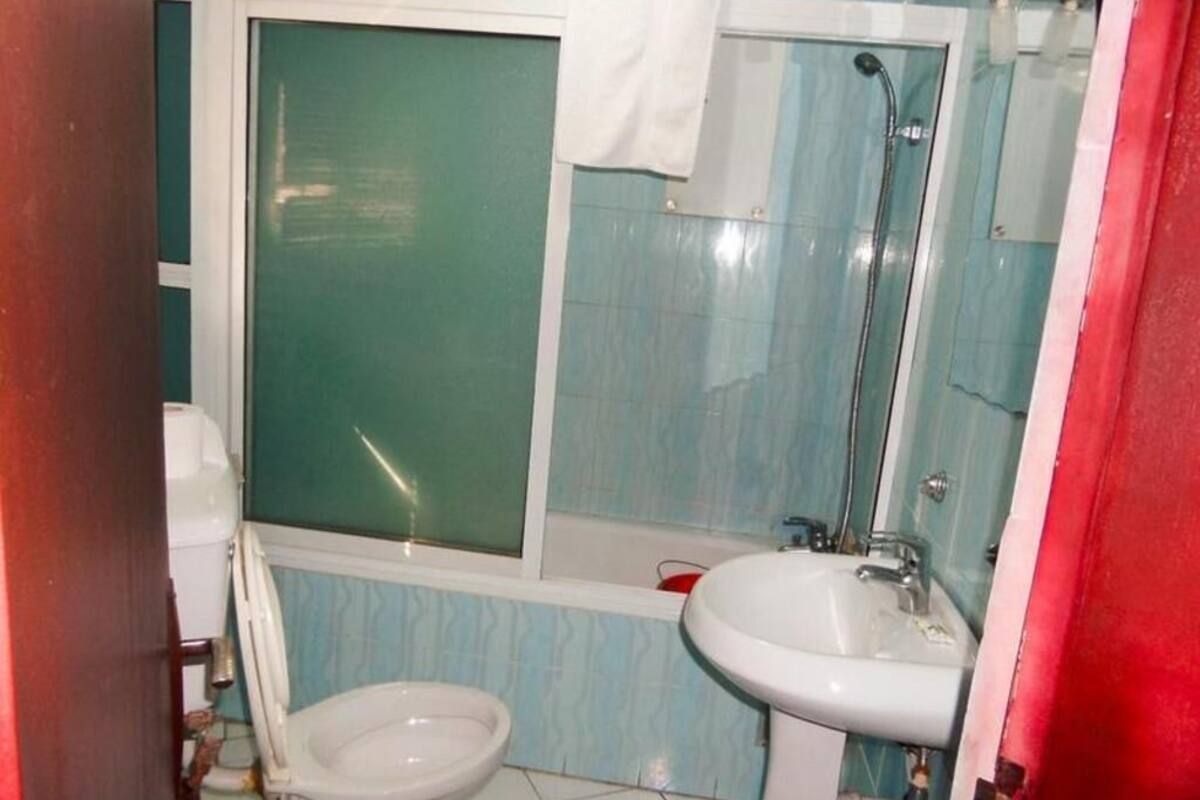 A bathroom with a toilet, a sink, and a shower.