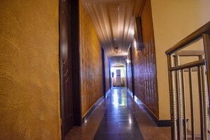 A long, narrow hallway with a polished floor and textured walls.