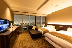 A hotel room with a city view, a desk with a computer, a bed, and a sofa. - Piazza Hotel Nara (Nara)