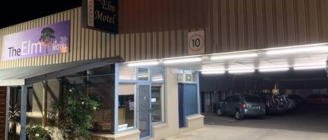 El Motel Elm con recepción, aparcamiento y un cartel que indica un límite de velocidad de 10.
