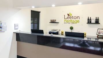 Bancada de recepção no Leeton Heritage Motor Inn, com design limpo e moderno.