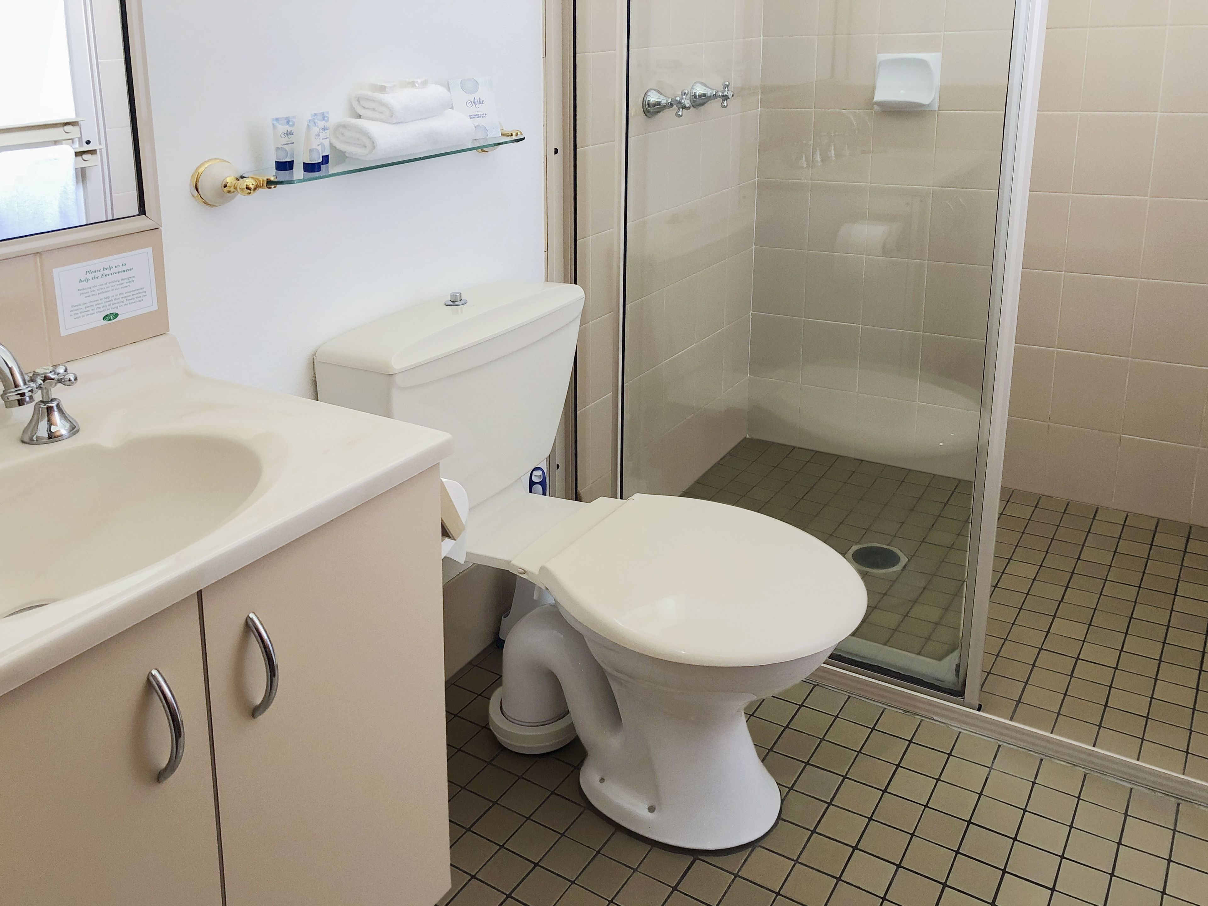 Een badkamer met toilet, wastafel en douche.