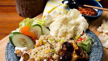 Ein Teller gebratenen Reis mit Gemüse und Fleisch, dazu eine Schüssel Suppe und eine kleine Salatschüssel.