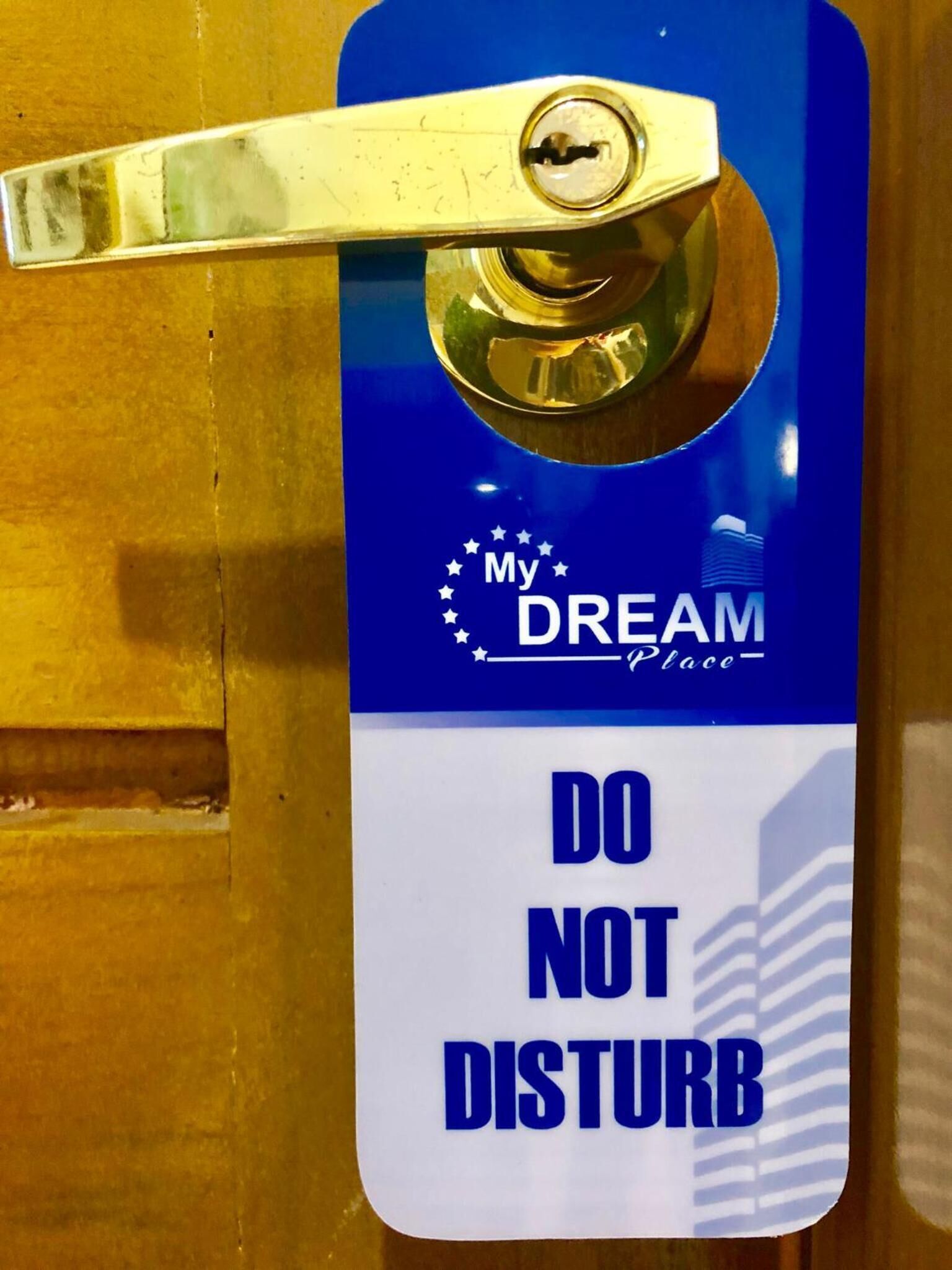 Una puerta con un letrero azul y blanco que dice 'DO NOT DISTURB' y 'My DREAM Place'.