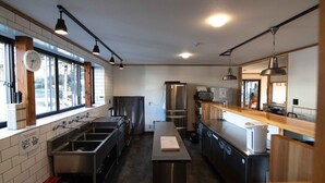 Una cocina moderna con electrodomésticos de acero inoxidable, detalles de madera y ventanas amplias.