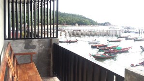 A balcony with a wooden bench overlooking a harbor with numerous boats. - Bro&Sis Place (Koh Tao)