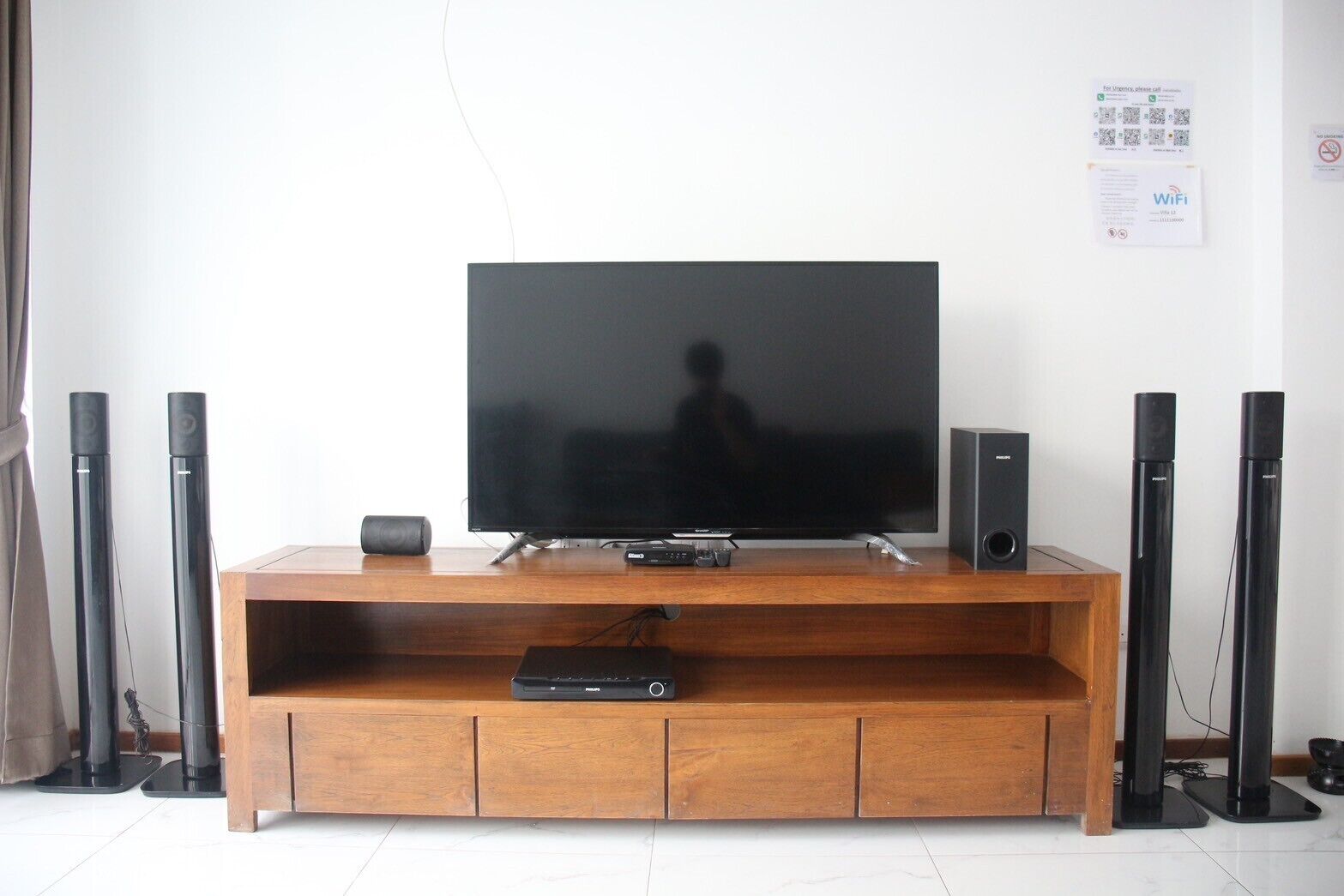 A flat-screen TV on a wooden TV stand with two speakers on either side.