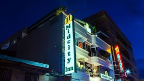 A building with a prominent 'Midcity Inn' sign, a balcony with a 'Midcity Cafe' sign, and a 'Midcity' sign on the side. - JJ Midcity Inn (Tabaco City)