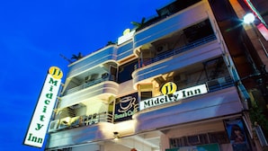 A multi-story building with balconies and signage for Midcity Inn and Kimcare. - JJ Midcity Inn (Tabaco City)