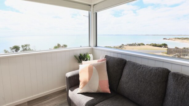 A balcony with a view of the sea and a beach.